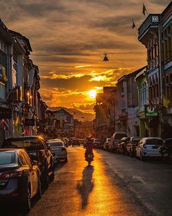 Parked cars on the street of an old town at sunset