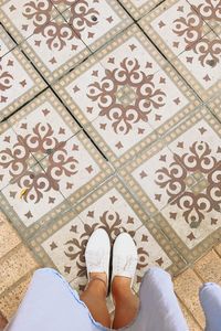 Low section of woman standing on tiled floor