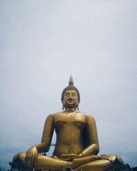 Statue against temple against sky