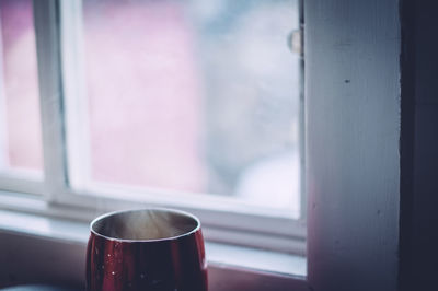 Close-up of coffee in cup by window