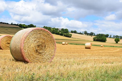 Hay bales on field against sky