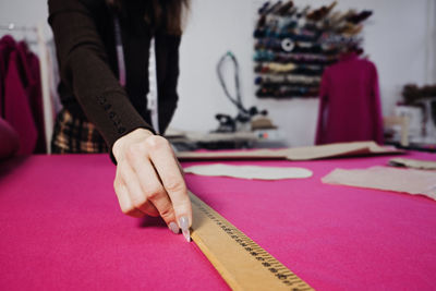 Hand cutting pattern and fabric pieces. fashion design. female tailor, seamstress working with