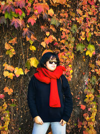 Full length of woman standing by plants during autumn