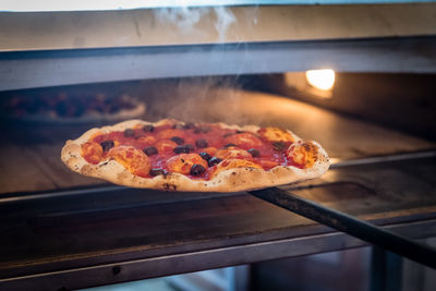 Smoke from freshly baked pizza in commercial kitchen