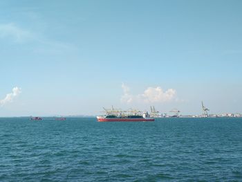 Ship sailing on sea against sky