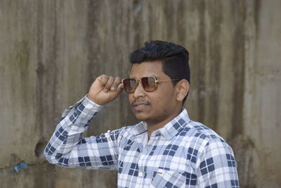 Portrait of young man wearing sunglasses standing outdoors