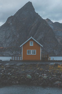 House amidst rocks and mountains against sky