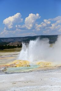 Geyser emitting smoke at yellowstone national park against sky