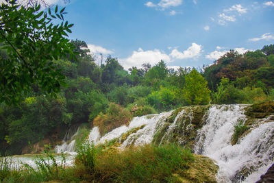 Scenic view of waterfall against sky