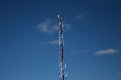 Low angle view of communications tower against blue sky