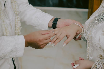 Midsection of bride holding wedding dress