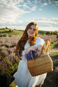 Portrait of smiling young woman sitting on field