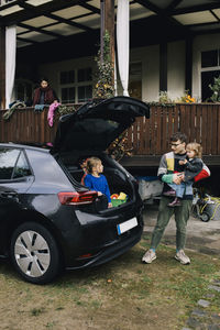 Father talking with daughter in trunk of electric car