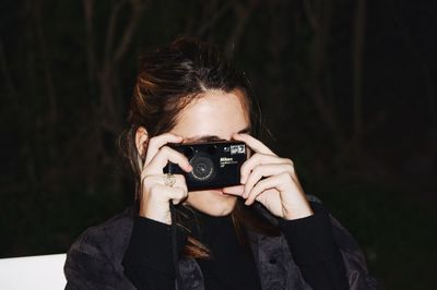 Portrait of young woman photographing
