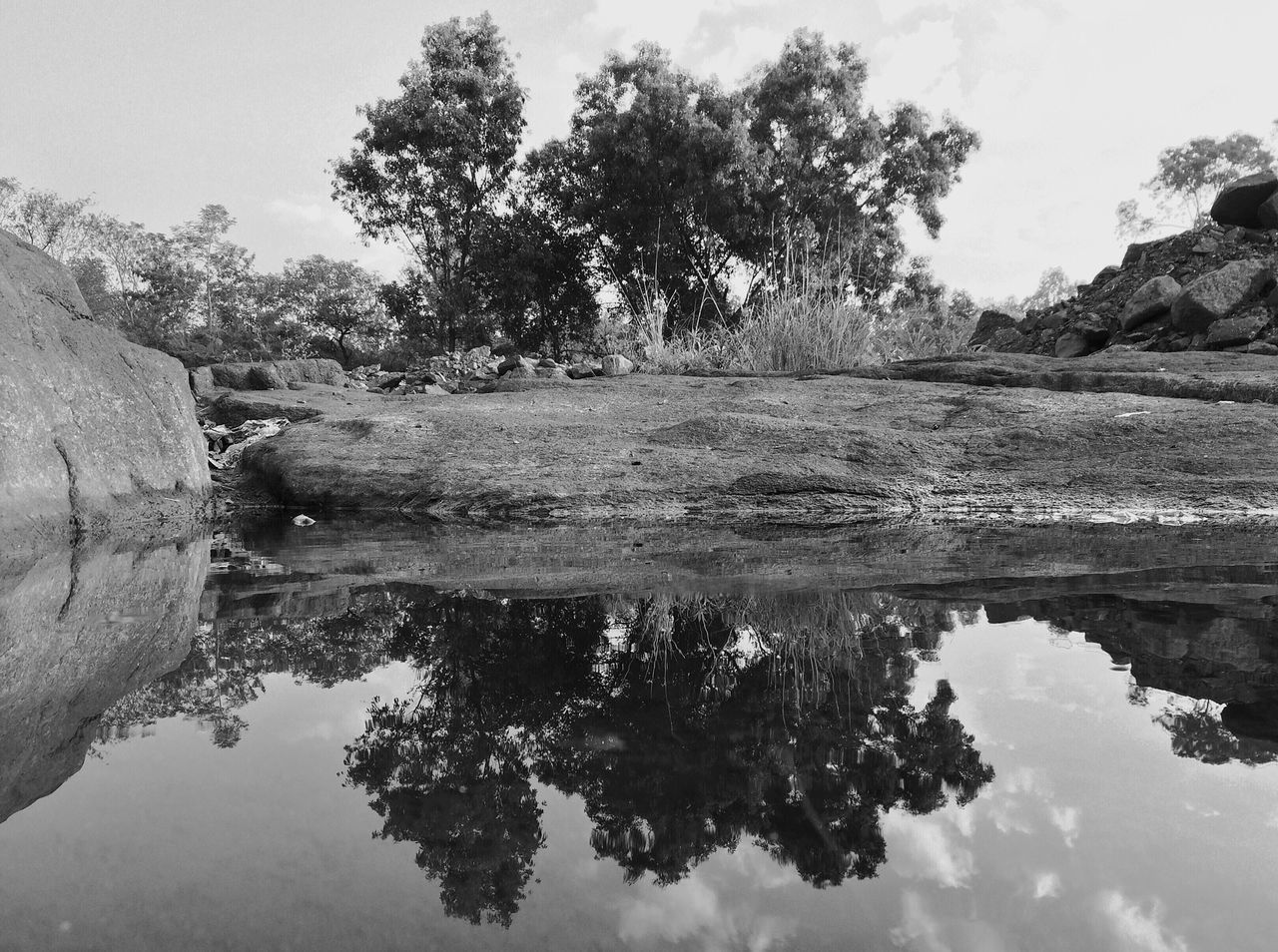 water, reflection, tranquility, tranquil scene, lake, scenics, tree, beauty in nature, nature, waterfront, sky, standing water, idyllic, rock - object, river, non-urban scene, day, outdoors, growth, non urban scene
