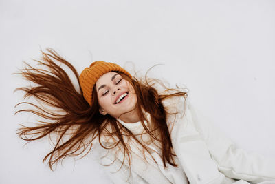 Portrait of young woman against white background