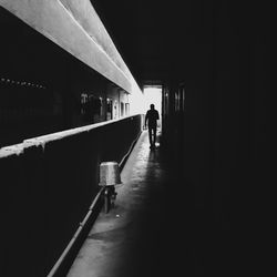 Rear view of people walking in illuminated building