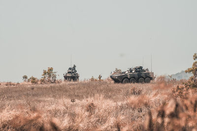 Panoramic shot of vehicle on field against clear sky