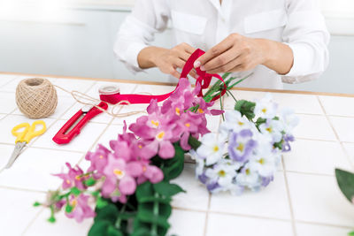 Midsection of woman making bouquet in flower shop