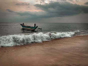 People at beach against sky