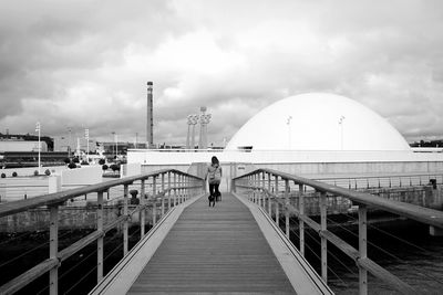 Rear view of man walking on footbridge