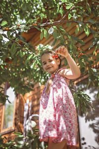 Full length of girl standing against plants