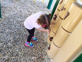 High angle view of girl playing with play equipment at playground