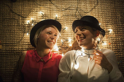 Two friends lying on the floor with fairy lights