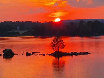 Scenic view of lake against orange sky