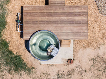 Drone view of a wood fired stainless steel outdoor jacuzzi and a wooden deck at a luxury hotel.