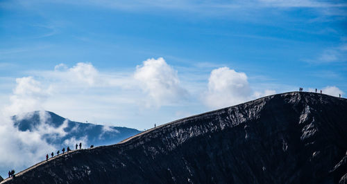 Hikers on mountain against sky