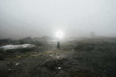 Human exploring a foggy landscape