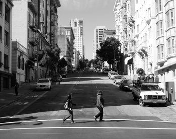 People walking on road along buildings