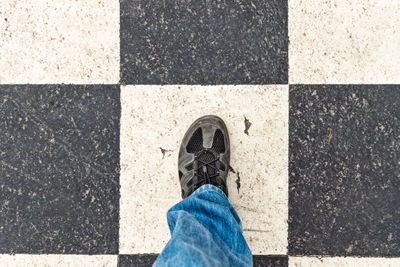 Low section of person standing on tiled floor