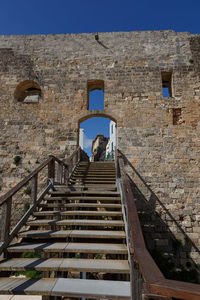 Low angle view of people on staircase against sky