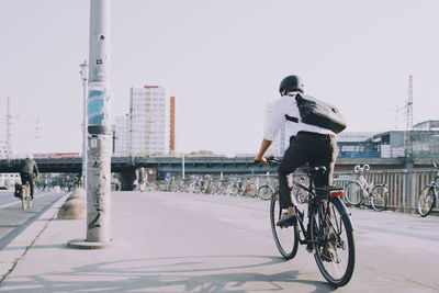 Rear view of man riding bicycle in city