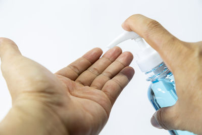 Close-up of hand holding hands over white background