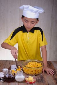 Boy preparing food on table at home