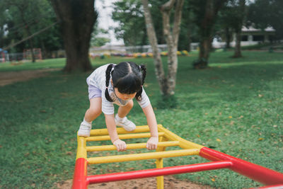 Rear view of woman exercising on field