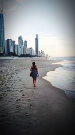 Full length of woman standing at seaside