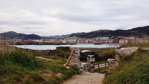 Scenic view of lake by buildings against sky