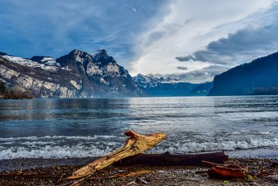 Scenic view of sea and snowcapped mountains against sky