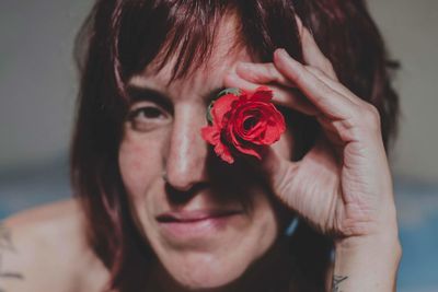 Close-up portrait of woman holding red rose