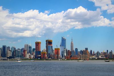 Sea by buildings against sky