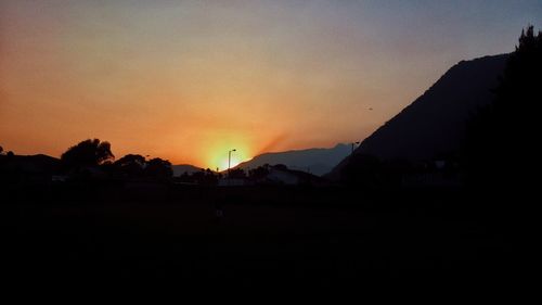 Scenic view of silhouette mountains against clear sky at sunset