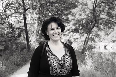 Portrait of smiling young woman against trees