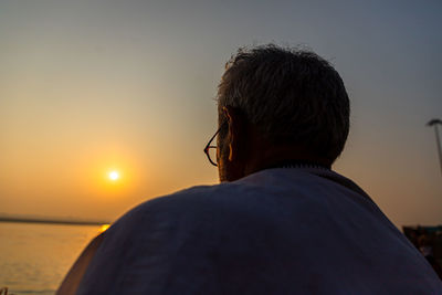 Rear view of man looking at sunset