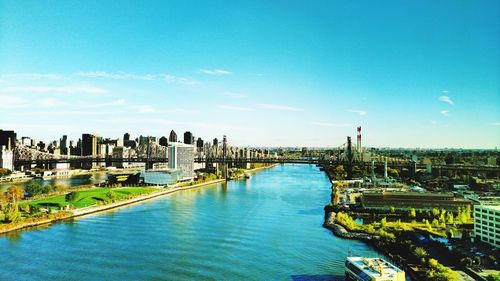 City at waterfront against blue sky