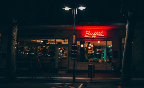 Illuminated street light in city at night