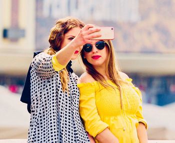 Young woman using mobile phone while standing outdoors